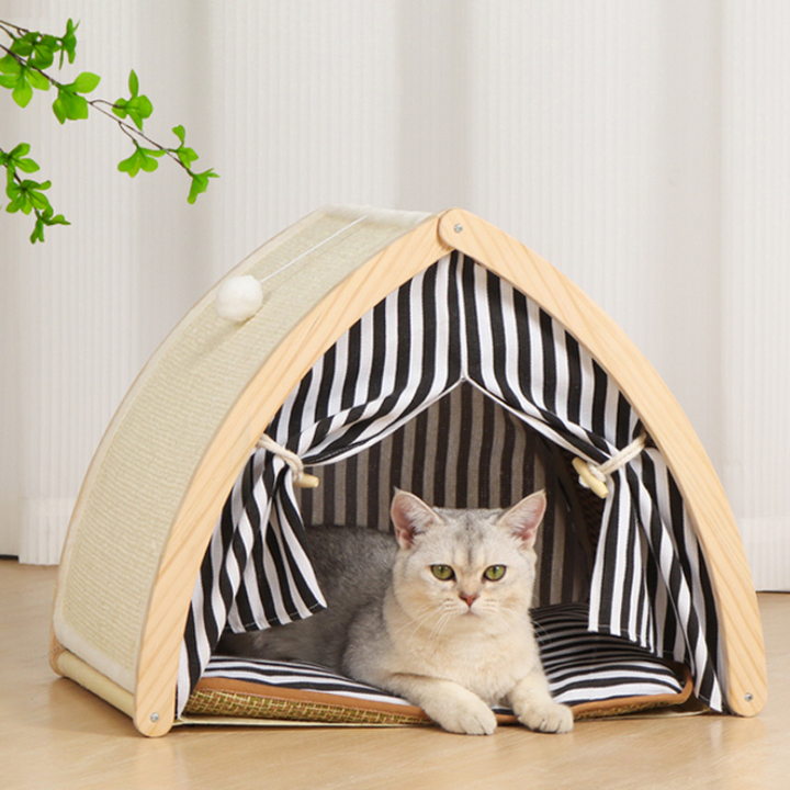 a cat is lying in a wood pet tent with black white stripe