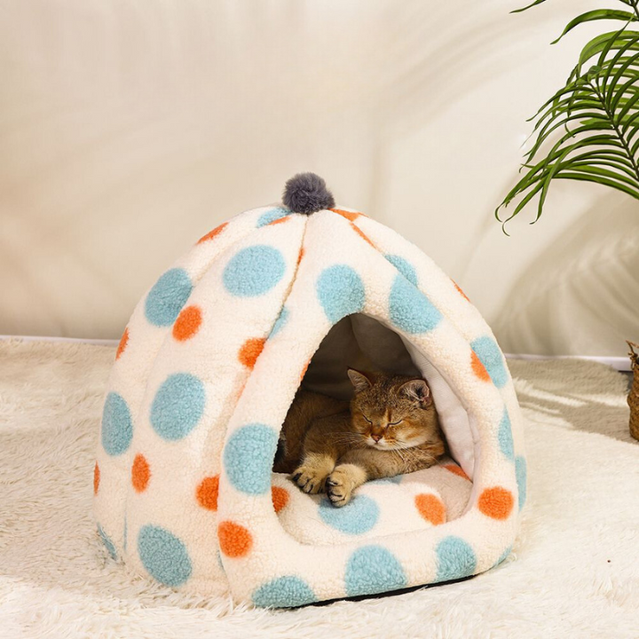 a cat is taking snap in blue polka dot igloo bed