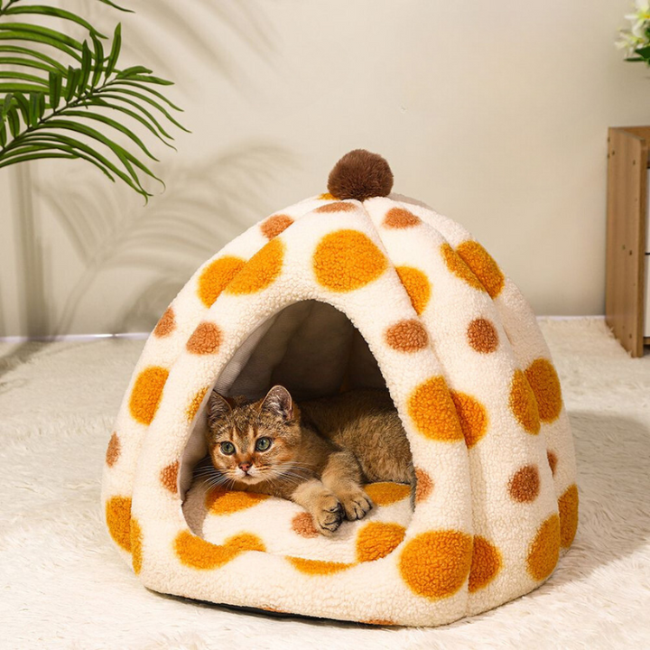 an addorable cat is lying in a igloo bed